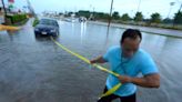 Photos of flooding in drought-stricken Dallas show water rushing through homes and cars submerged on waterlogged roads