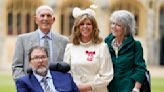 Kate Garraway is watched by Derek Draper as she receives MBE