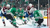 The Colorado Avalanche's Nathan MacKinnon fights for the puck in front of Dallas Stars goaltender Jake Oettinger during the second period in Game 1 of the second-round playoff...