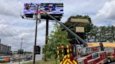 1 down, 2 others stuck on lift while working on Brookhaven billboard, officials say