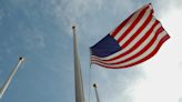 Why are U.S. flags being lowered to half-staff across Kansas?