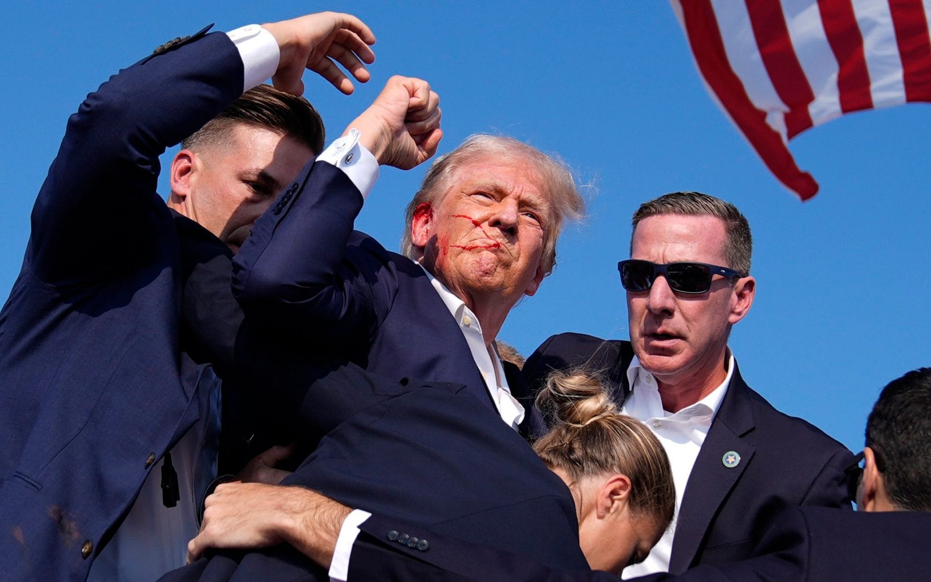 Bloodied Donald Trump carried from stage after deadly shooting at rally