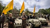 Hezbollah fires dozens of rockets at Israeli kibbutz after drone strike wounds civilians