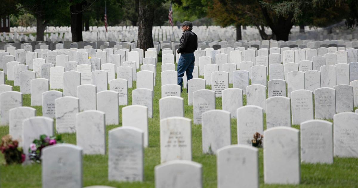 A visitor to Fort Logan National Cemetery pays their respects