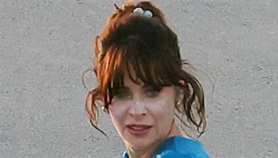 Zooey Deschanel rocks a quirky blue swimsuit as she frolics on the beach in North Carolina during shoot for new rom-com Merv
