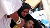 A pilgrim affected by scorching heat is helped by other Muslims in Mina, near Saudi Arabia's holy city of Mecca