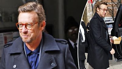 Simon Baker looks stylish in a designer coat and white pants as he leaves the Kelly and Mark show in New York