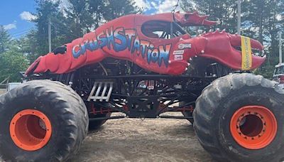 Lobster-themed monster truck clips aerial power line, toppling utility poles in spectator area