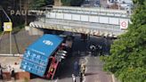 Road blocked after lorry hits bridge and overturns in east London