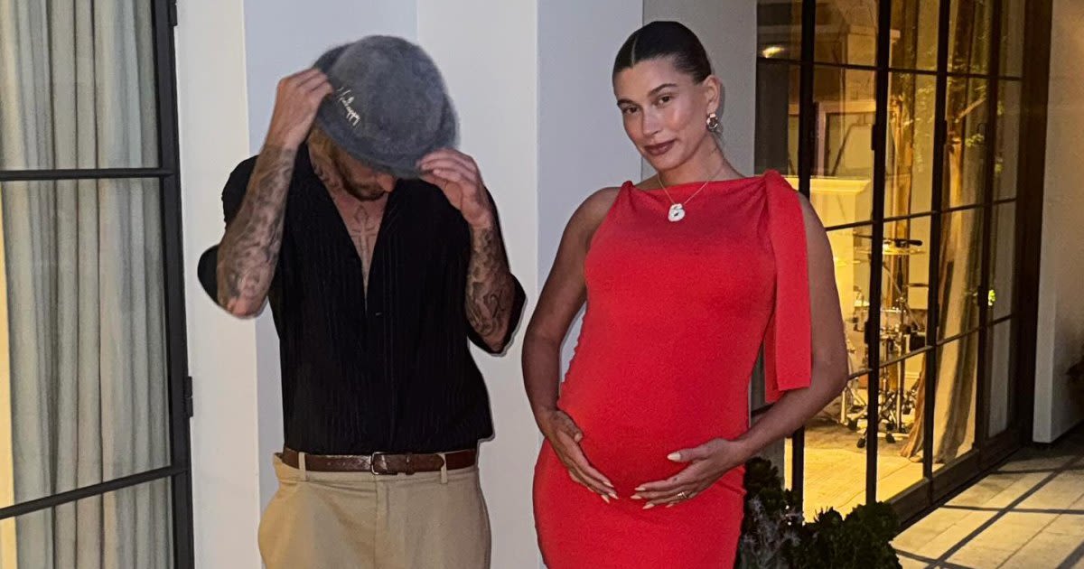 Pregnant Hailey Bieber Cradles Her Baby Bump in Ruby Red Frock With Justin Bieber