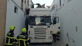 Un camión queda atascado en una calle al engancharse su carga con un balcón de Sanlúcar, en Cádiz