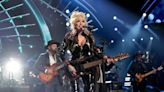 Dolly Parton jokes she’ll ‘hopefully drop dead in the middle of a song’ someday before she ever retires