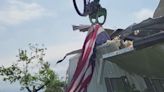 Cleanup crew pulls American flag from rubble after tornado hits home