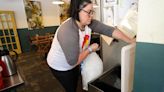 Sun in my Belly general manager Megan Cook dumps a bag of ice into the safe ice bin for their lunch customers at the restaurant in the Kirkwood neighborhood, Monday, June 3, 2024, in Atlanta.