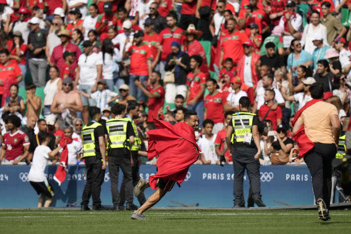 Morocco fans rush field during Olympic soccer opener vs Argentina. Game suspended, goal disallowed