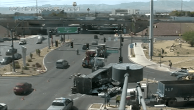 Semi-truck carrying crushed vehicle flips on side in central Las Vegas valley