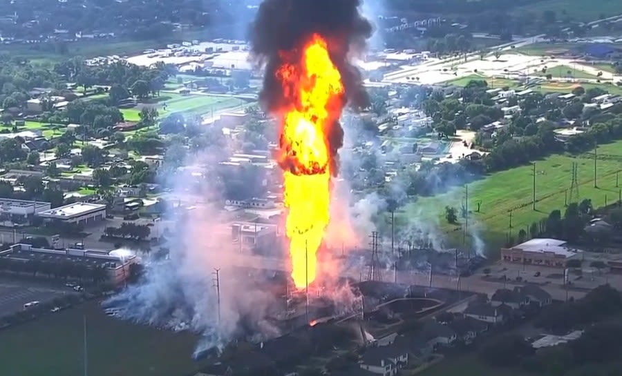 A pipeline explosion is shooting a towering pillar of flame over a Houston suburb