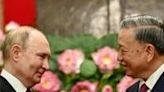 Russian President Vladimir Putin (L) is greeted by his Vietnamese counterpart To Lam at the Presidential Palace in Hanoi on Thursday