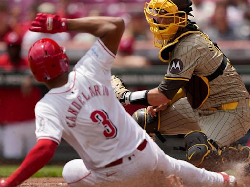 Kyle Higashioka of the San Diego Padres tags out Jeimer Candelario of the Cincinnati Reds at home plate in the first inning at Great American Ball...