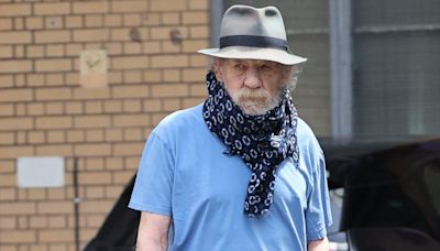 Sir Ian McKellen hides neck brace with a scarf after falling off west end stage