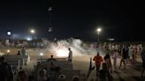 Crowd of teens fight on the beach, light fireworks on the boardwalk in Bethany Beach