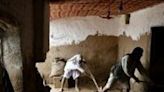 Afghan men shovel mud from a house following flash floods after heavy rainfall in Baghlan province