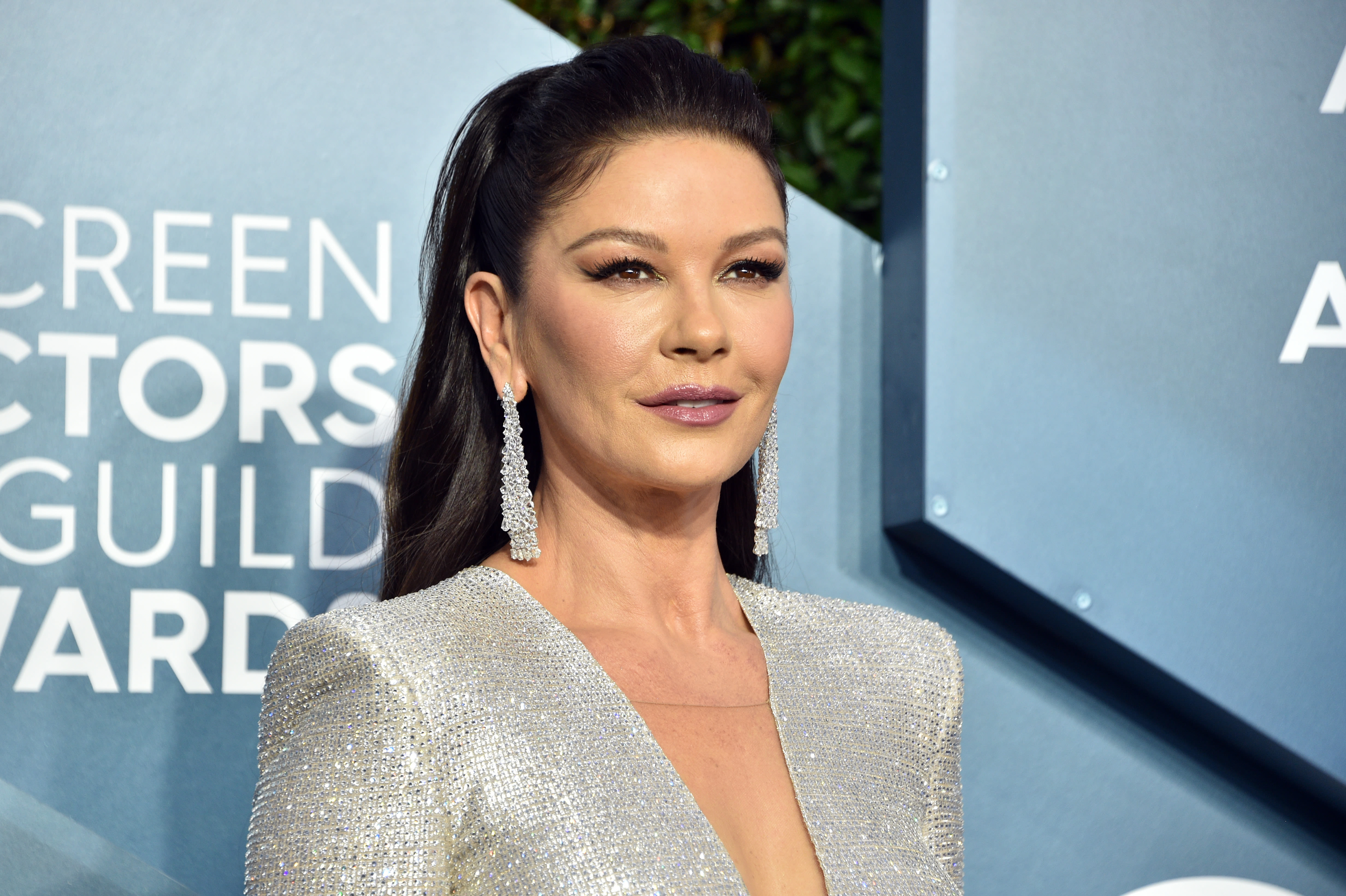 Catherine Zeta-Jones, 51, is still hula-hooping — this time, in a striped bikini