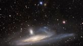 Telescope's dark energy camera captures large galaxy absorbing smaller one