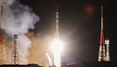 Craft carrying two Russians and an American docks at space station