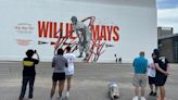 Surreal scene as artists finish Mays mural morning after he died