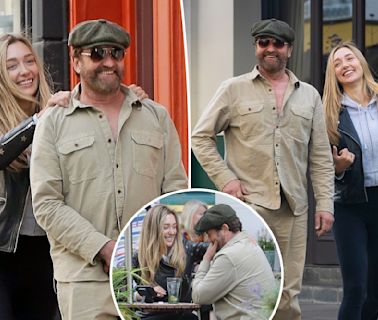 Gerard Butler, 54, all smiles as he cozies up to Sports Illustrated model, 29, during stroll in London