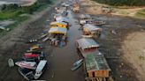 A floating village is stranded on a dry lakebed as extreme drought grips the Amazon