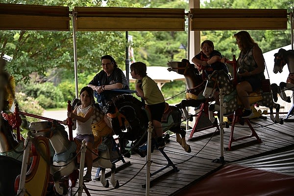 Visitors enjoy free rides of 100-year-old Over-the-Jumps Carousel at the Little Rock Zoo | Arkansas Democrat Gazette