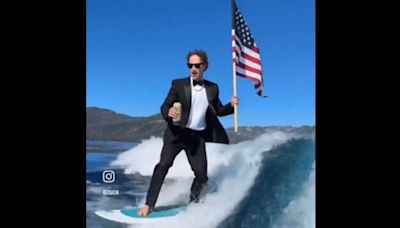 With US flag in hand, Mark Zuckerberg surfs in a suit while drinking beer