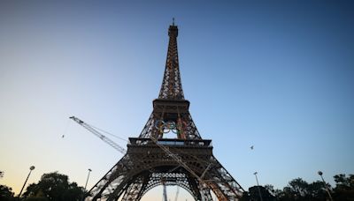 The Olympic rings are mounted on the Eiffel Tower to mark 50 days until the Paris Games