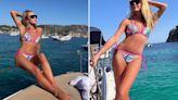 Amanda Holden hangs off the side of a boat in tiny bikini