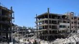 Gazans returning to Jabalia walk through the rubble-strewn streets, now full of grey concrete slabs