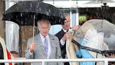 Lip reader on Charles' blunt demand as he helps struggling Camilla in harsh rain