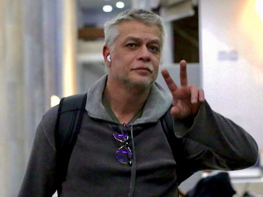 De look de moletom, Fabio Assunção acena para fotógrafos ao desembarcar no Rio