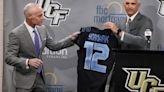 ...Yormark, left, is presented with a personalized jersey by University of Central Florida athletic director Terry Mohajir during...conference at UCF on Oct. 26, 2022, in Orlando, Florida.