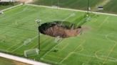 Watch horror moment football pitch collapses as 100-FOOT sinkhole swallows field