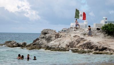 Gunmen on jet skis open fire at rival drug dealer at a beach in Cancun, killing a 12-year-old boy