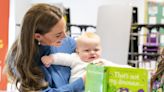 Kate cuddles baby as she learns about innovative education project