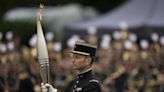 The Olympic torch lights up France's Bastille Day military parade