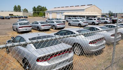 A fenced lot in Salem has dozens of silver Chargers and Durangos. Why is that?