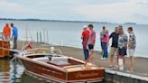 Lakeside event features wooden boats, outdoor artists