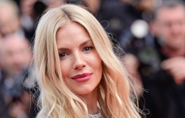 Sienna Miller is a boho vision in white detailed lace top and tiny shorts