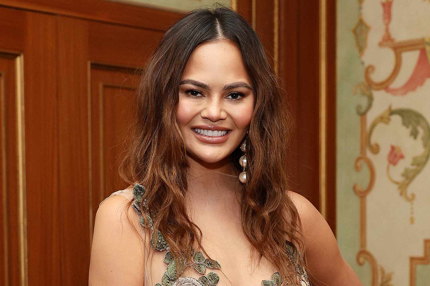 Chrissy Teigen Covers “SI Swimsuit” in Barely There One-Piece 10 Years After Her Last Sexy Appearance