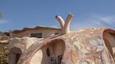 A mosaic-encrusted curved shell home was built after a devastating California wildfire burned the owners' original property down. Take a look.