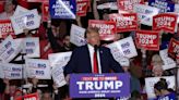 ...presidential candidate and former President Donald Trump hold up signs as he speaks during a campaign event at Greensboro Coliseum on March 2, 2024, in Greensboro, North Carolina.